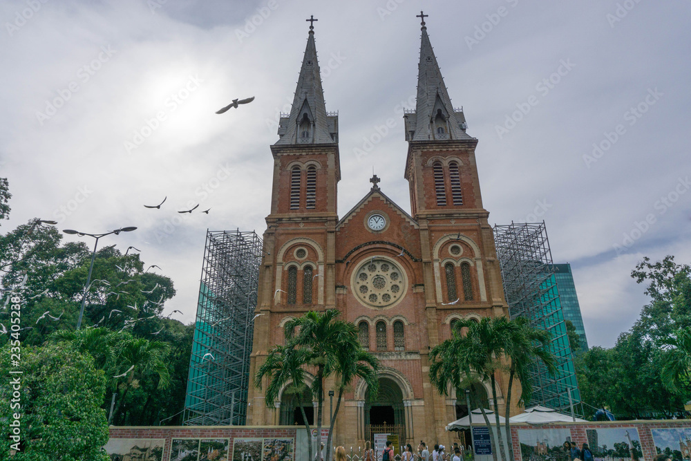 Obraz premium Birds flying towards the Sun at Notre Dame Cathedral of Saigon