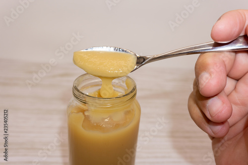 Cauliflower and zucchini baby puree in bowl with baby spoon on blue background top view