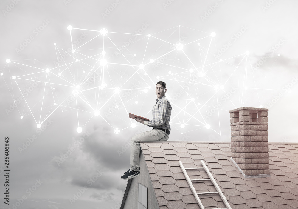 Man on brick roof reading book and concept of social connection Man on brick roof reading book and concept of social connection