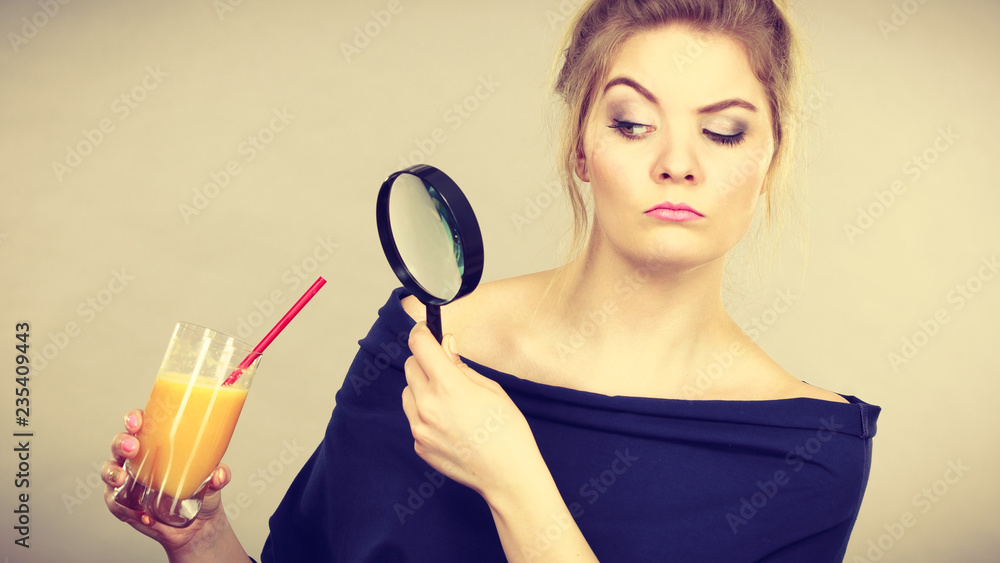Woman holding magnifying glass investigating bread Woman holding magnifying glass investigating bread