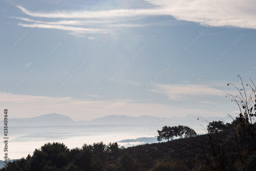 Obraz premium Fog filling a valley in Umbria (Italy), with layers of mountains and hills and various shades of blue