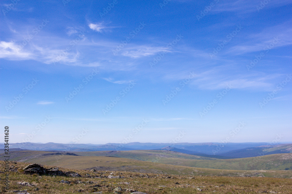 Awesome panorama for a postcard or calendar. Blue cloudy sky and mountain view in the distance. Nature of the Northern Urals.