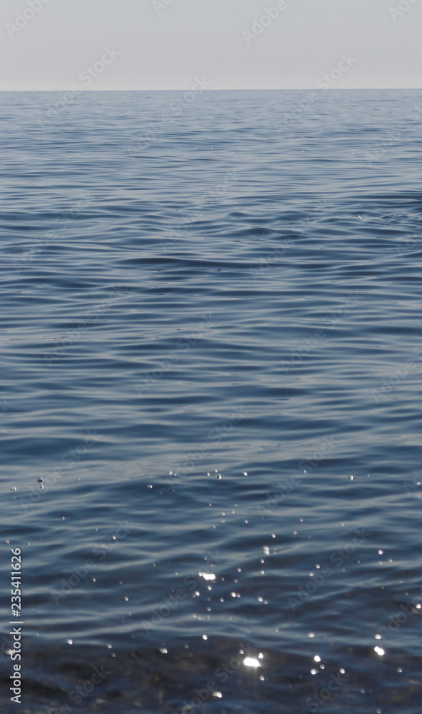Close up of sparkling surface of sea with waves and sky background Close up of sparkling surface of sea with waves and sky background