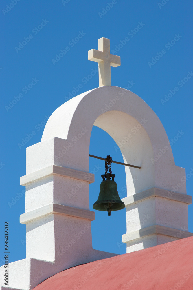 White Cross and Church Steeple in front of a blue sky on the island of Mykonos, Greece White Cross and Church Steeple in front of a blue sky on the island of Mykonos, Greece