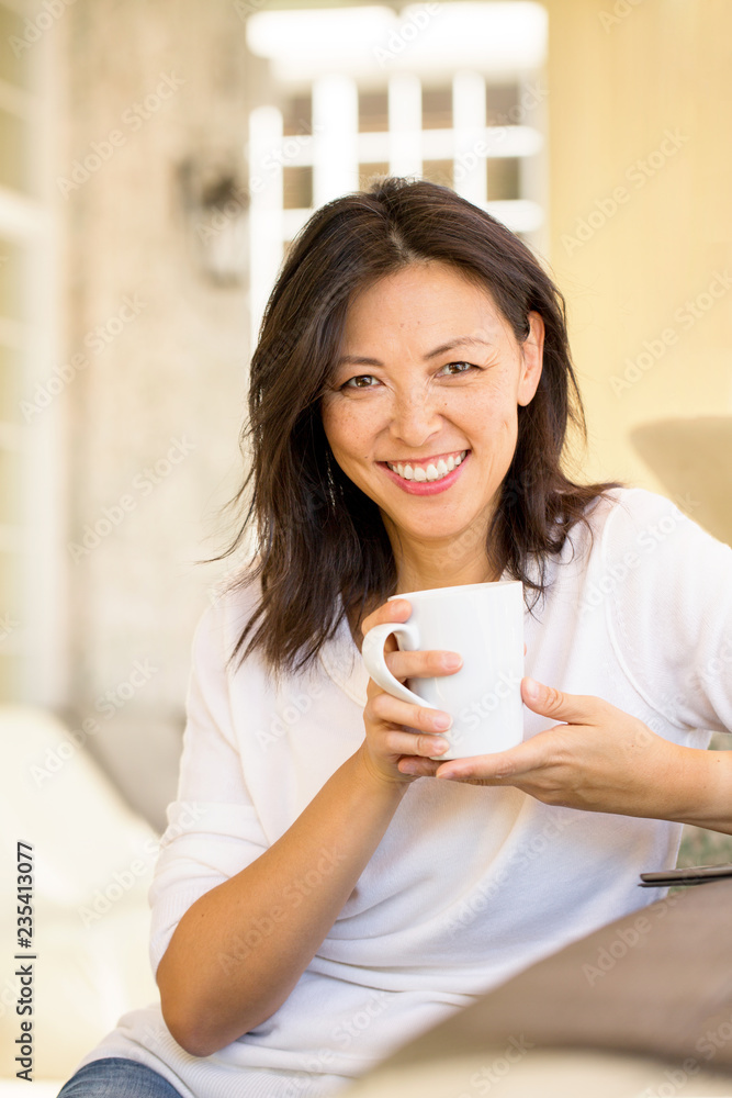 Portrait of an Asian woman smiling and drinking coffee. Portrait of an Asian woman smiling and drinking coffee.