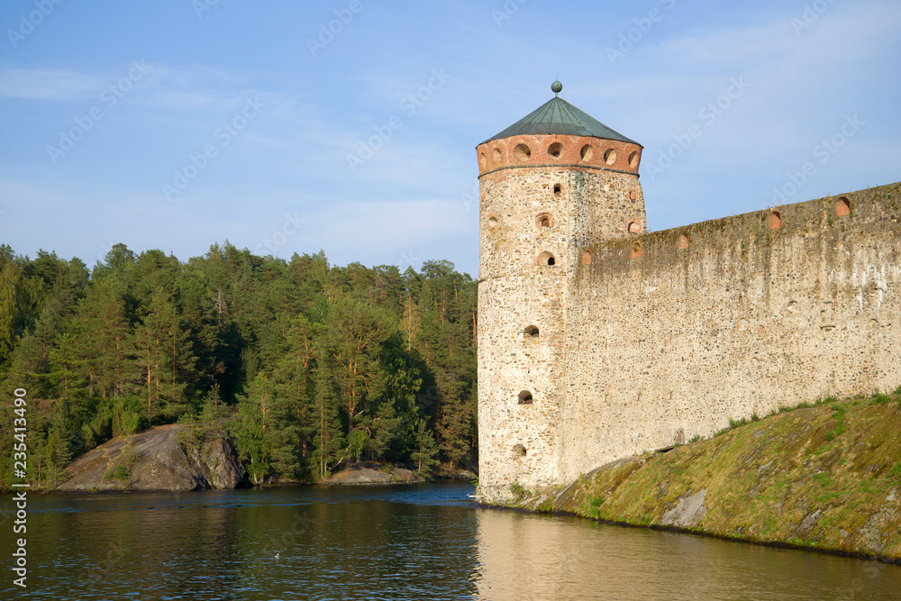 The tower of the medieval fortress Olavinlinna close up against the backdrop of the coast. Savonlinna, Finland