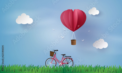 . love and valentine day,Origami made hot air balloon fly over grass  and red bicycle .paper art style.