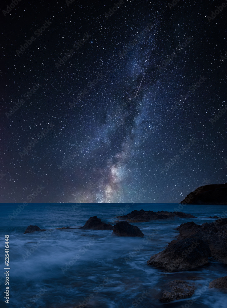 Vibrant Milky Way composite image over landscape of beautiful rocky coastline in Mediterranean Sea