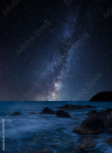 Vibrant Milky Way composite image over landscape of beautiful rocky coastline in Mediterranean Sea