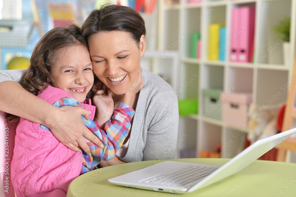 Portrait of happy mother and daughter using laptop Portrait of happy mother and daughter using laptop