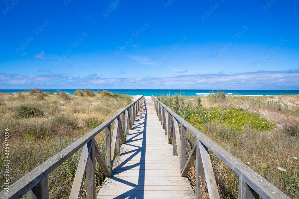 wooden walkway, with planks and banisters to preserve nature, straight direct to Palmar Beach and ocean water, in Vejer village (Cadiz, Andalusia, Spain)