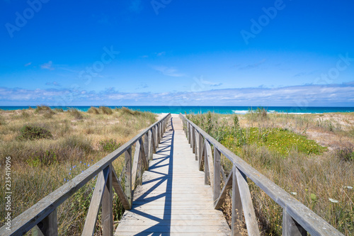 wooden walkway, with planks and banisters to preserve nature, straight direct to Palmar Beach and ocean water, in Vejer village (Cadiz, Andalusia, Spain)