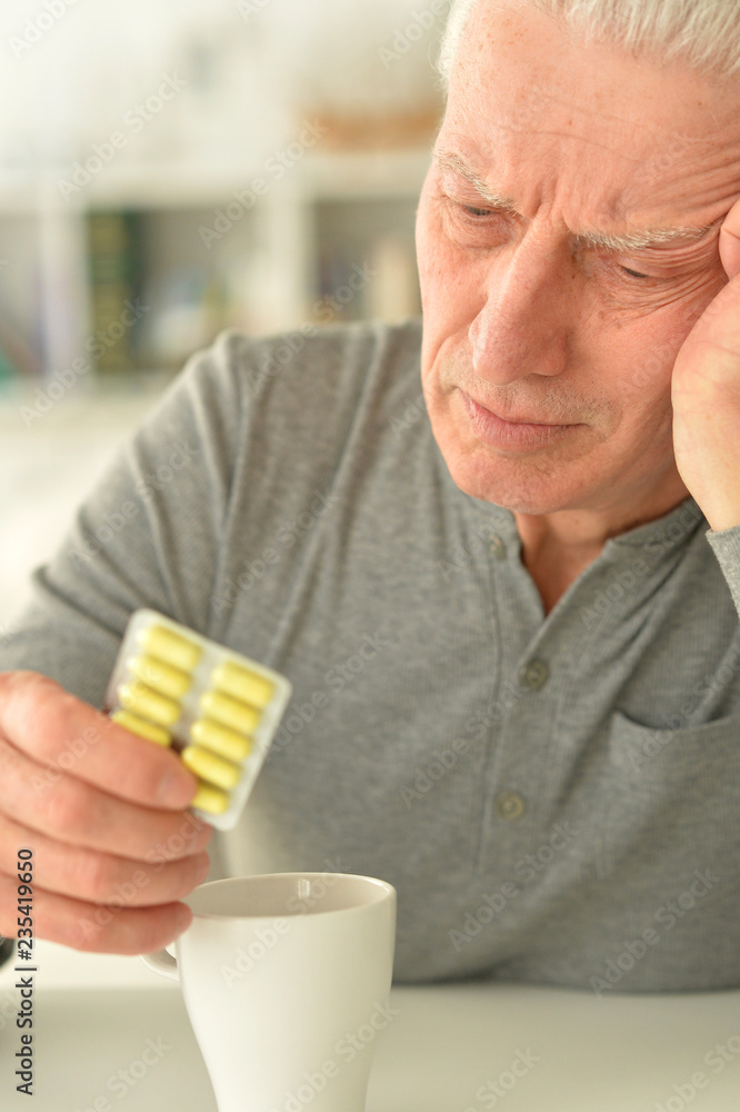 Elderly ill man with pills in hand Elderly ill man with pills in hand