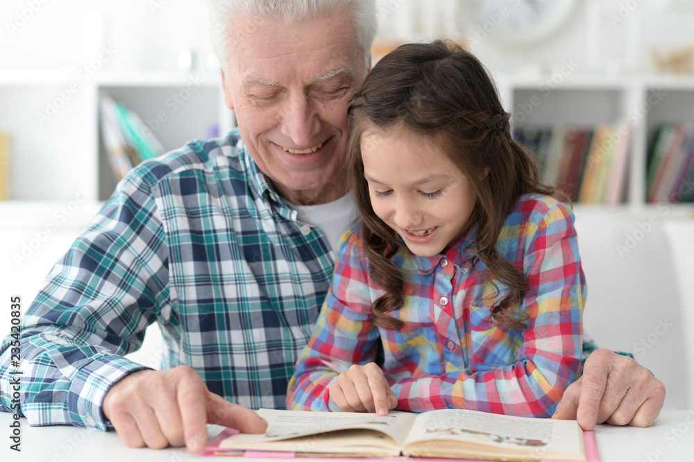 little cute girl with grandfather reading book little cute girl with grandfather reading book