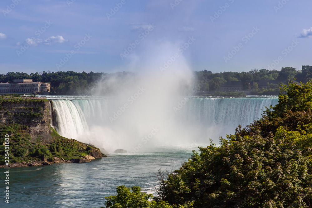 Wide view of the beautiful American side of the Niagara falls and a boat in front of it, from the Canadian side. Wide view of the beautiful American side of the Niagara falls and a boat in front of it, from the Canadian side.