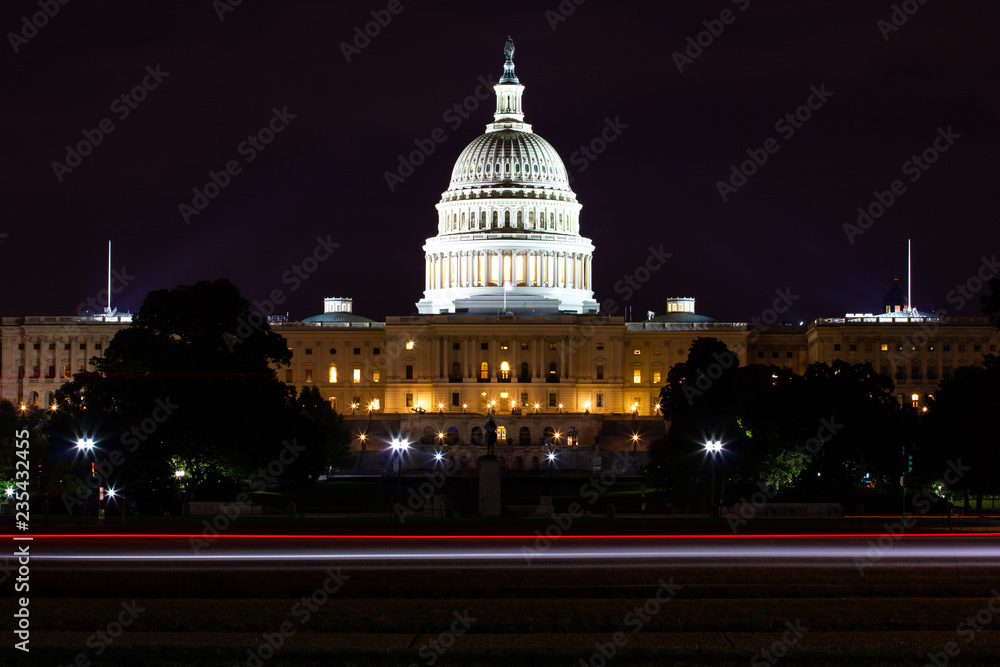 United States Capitol in Washington DC by night with a long exposure and traces of lights from the car passing by.