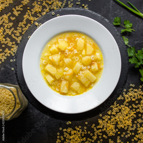 vegetable soup with pasta anelli and vegetables on table. Vegan food.  (dark background). top view. copy space photo