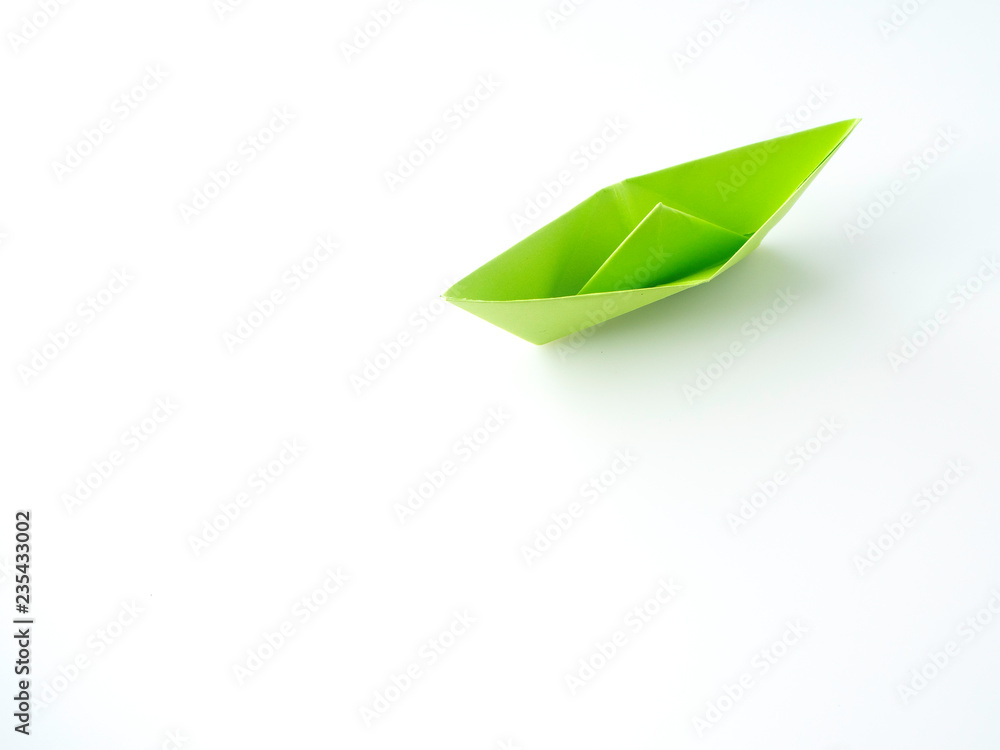 Green paper boat laid on white background.. Green paper boat laid on white background..