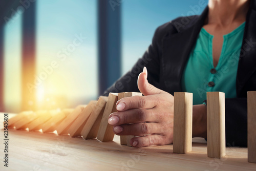 Фотография Businesswoman stops a chain fall like domino game