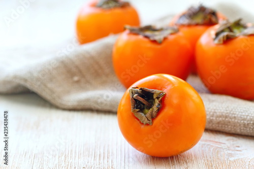 Ripe persimmon fruit on wooden table ready for eat photo