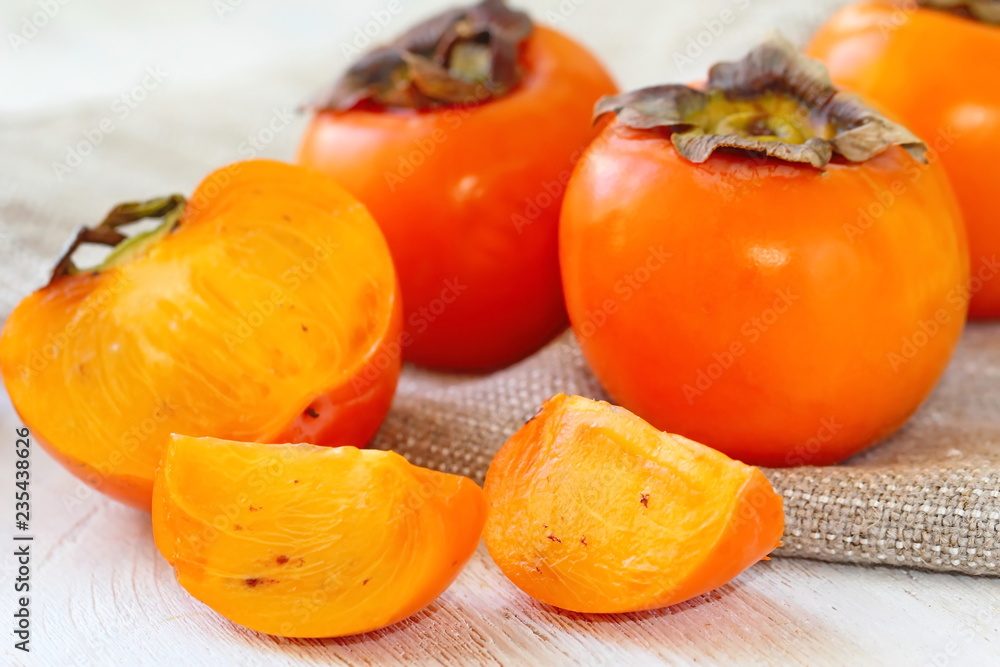 Ripe persimmon fruit on wooden table ready for eat