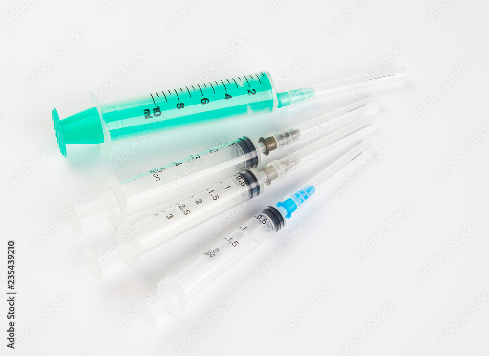 A set of disposable syringes for injections of different sizes on a white background. A set of disposable syringes for injections of different sizes on a white background.