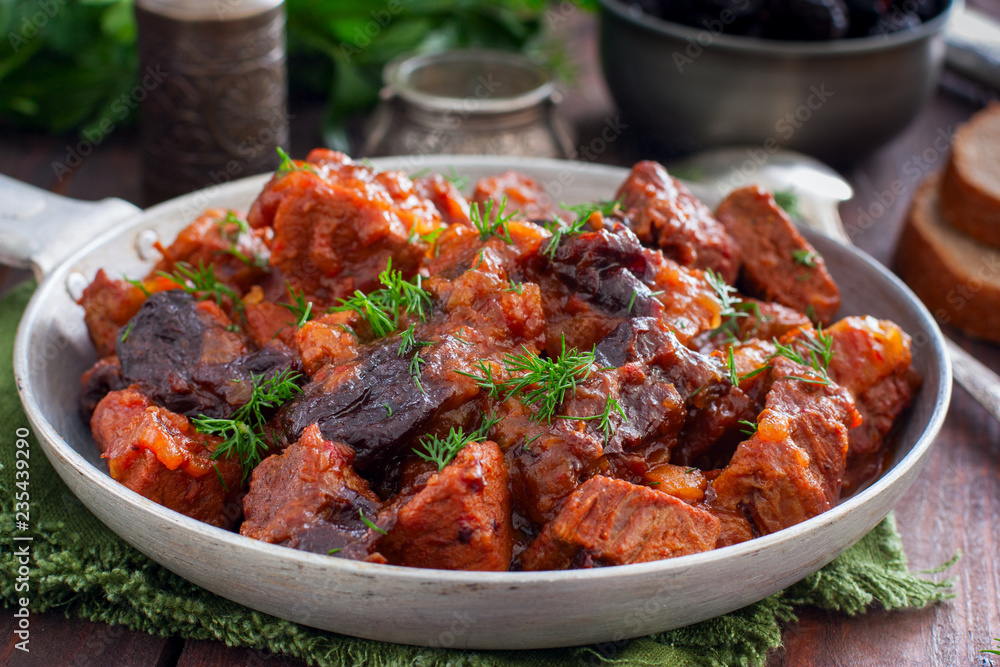 Beef with prunes in tomato sauce in a pan, horizontal