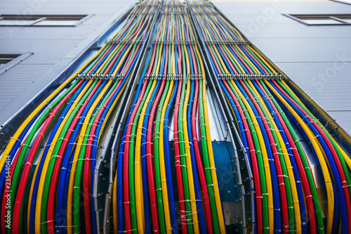 Different bright colors electric wires installed on the constructions of industrial building. photo
