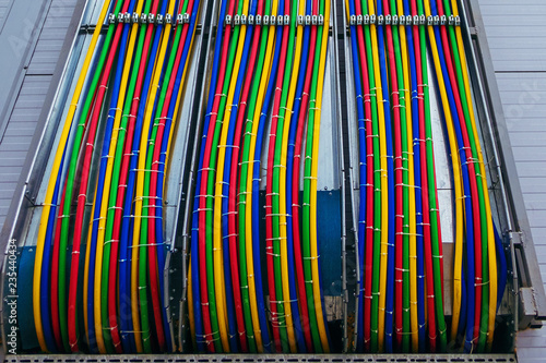Different bright colors electric wires installed on the constructions of industrial building.