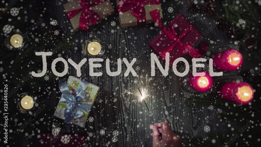 Greeting card Joyeux Noel, Merry Christmas in french language, falling snow, candles and gifts Greeting card Joyeux Noel, Merry Christmas in french language, falling snow, candles and gifts