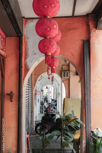 Beautifully trimmed and decorated doors and windows with shutters line the arch covered walkways and sidewalks overhung with red Chinese lanterns