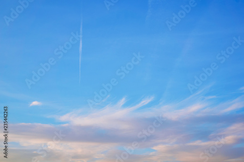 Wavy, porous curly clouds in the blue sky. Nature Background.