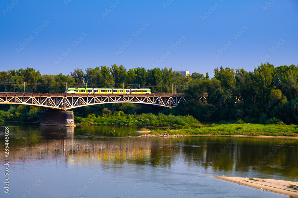 Warsaw, Poland - Panoramic view of the Vistula river with Most Srednicowy railway bridge and wooded Praga district of Warsaw - obrazy, fototapety, plakaty 