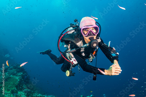 Female SCUBA diver swimming on a tropical coral reef