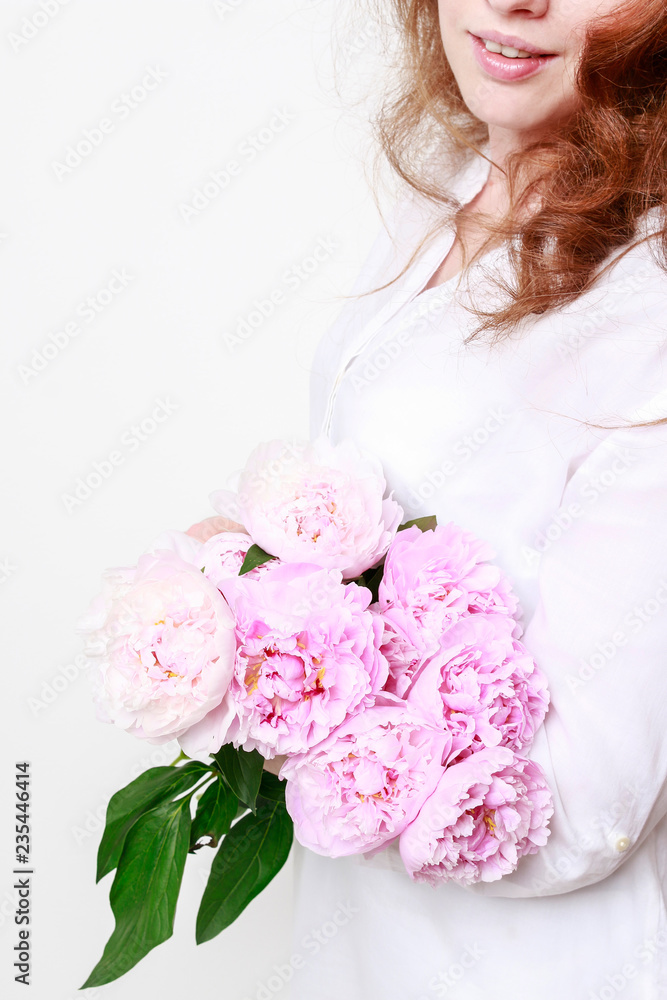 Woman holding pink peonies.