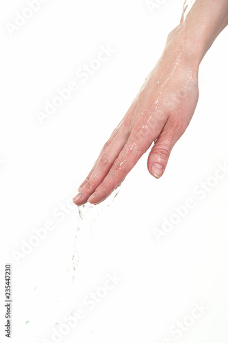 On the female hand runs clear water. Isolated on white background.
