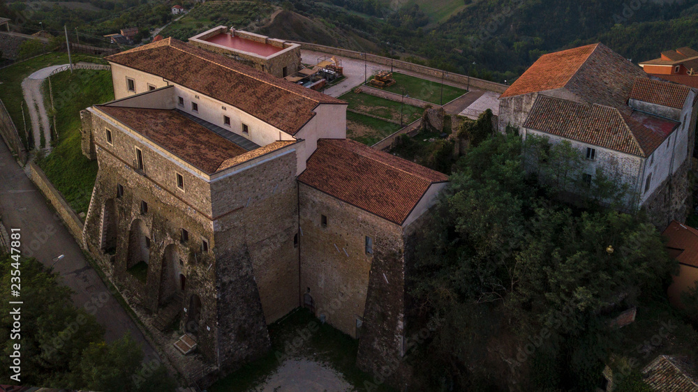 Fototapeta premium Aerial view at sunset of the castle built on the mountain where Montecalvo Irpino rises in Italy.