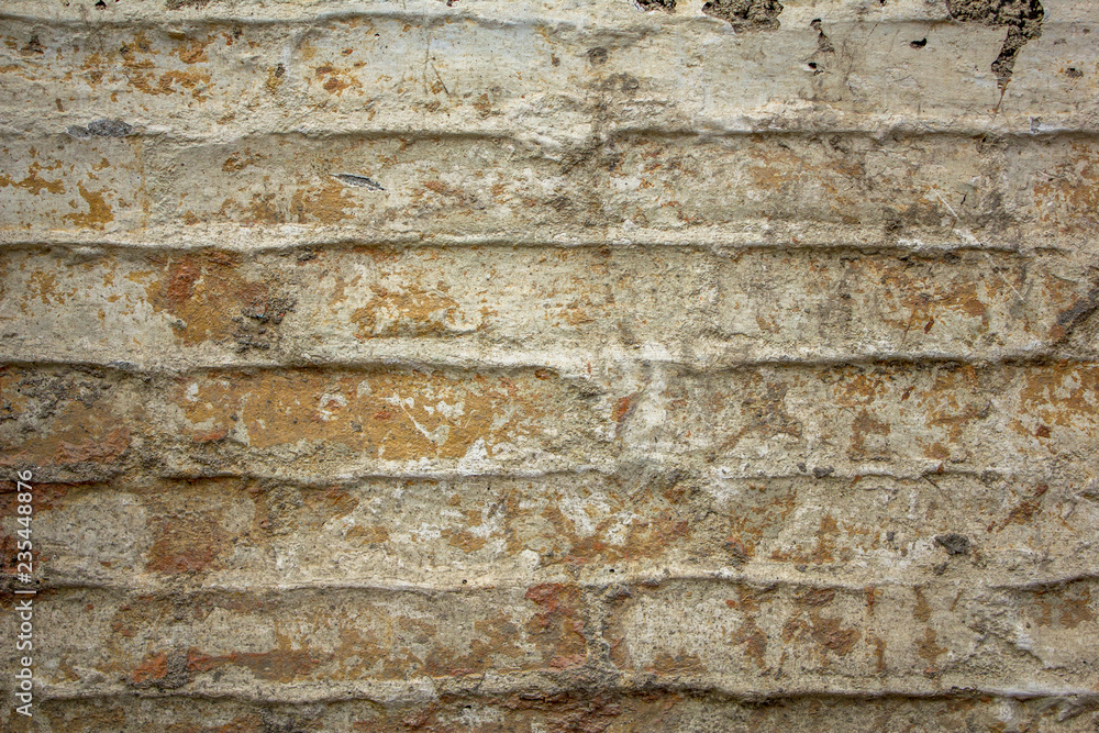 old damaged white gray brick wall with cracks. rough surface texture. spots of dirt and cement on the wall. horizontal lines