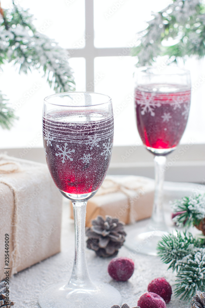 Festive berry liqueur in glass Christmas glasses on the table in the Christmas decorations, selective focus Festive berry liqueur in glass Christmas glasses on the table in the Christmas decorations, selective focus