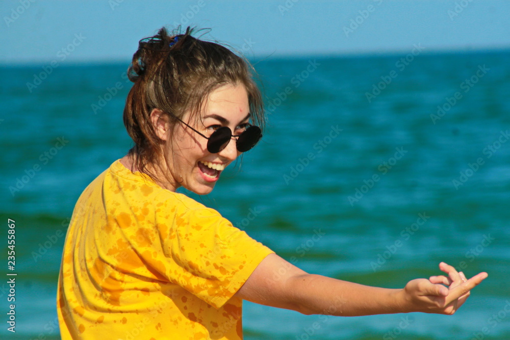 девушка радуется на берегу моря.