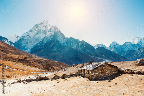 Stone house in the mountains and view of Mount Ama Dablam in Himalayas, Nepal.