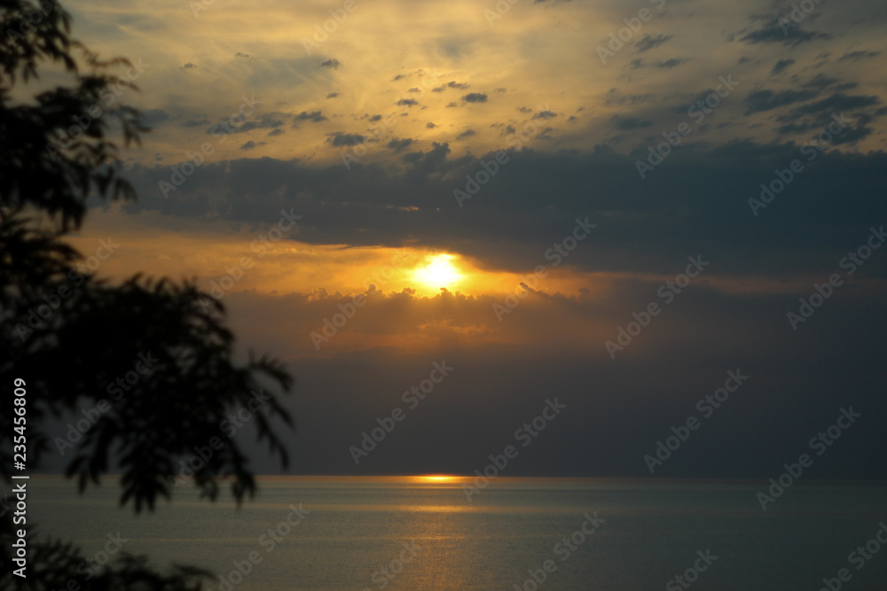 blue sky and sun, sunset on the shore, seascape, sunlight through the clouds