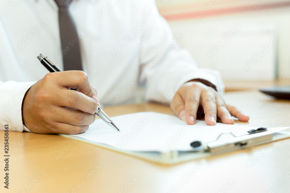Businessman signing contract paper with pen in office desk. Businessman signing contract paper with pen in office desk.