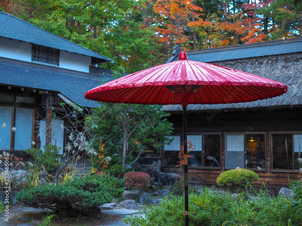 Japanese garden scene with red paper umbrella.
