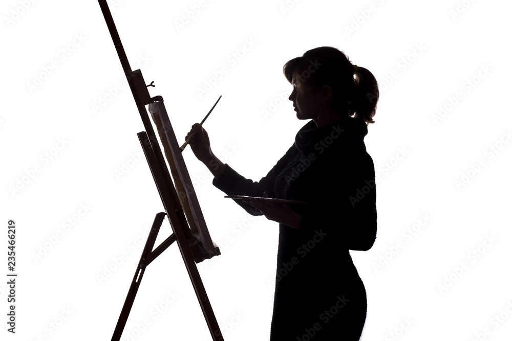 silhouette of a young woman painting on an easel on a white isolated ...