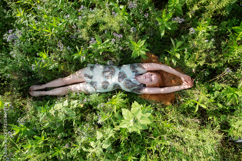 Schöne junge sexy rothaarige Frau, liegt entspannt auf der grünen Wiese, Gras, die in der Natur in der frischen Luft genießt Freude Freiheit Lust streckt glücklich die Arme nach oben Schöne junge sexy rothaarige Frau, liegt entspannt auf der grünen Wiese, Gras, die in der Natur in der frischen Luft genießt Freude Freiheit Lust streckt glücklich die Arme nach oben