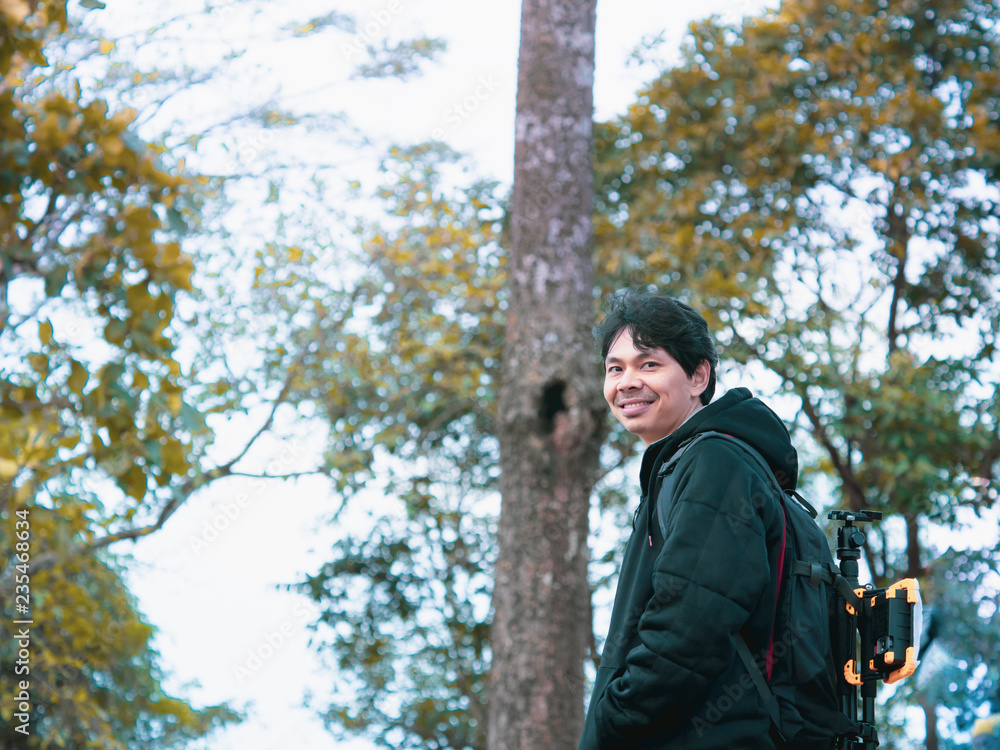 solo backpack and camping concept from backside of black hair man in warm hoodie sweatshirt with his bag solo travel, relax, happy and see to forest and mountain in morning after sunrise solo backpack and camping concept from backside of black hair man in warm hoodie sweatshirt with his bag solo travel, relax, happy and see to forest and mountain in morning after sunrise
