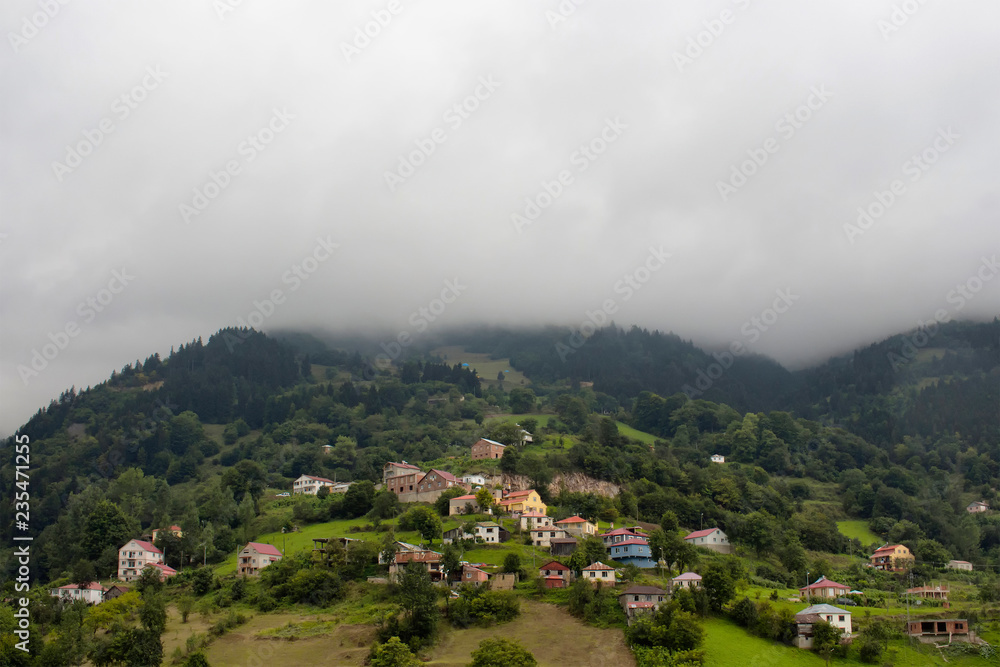 View of high plateau village, mountains, valleys and forest in fog creating beautiful nature scene. The image is captured in Trabzon/Rize area of Black Sea region located at northeast of Turkey.