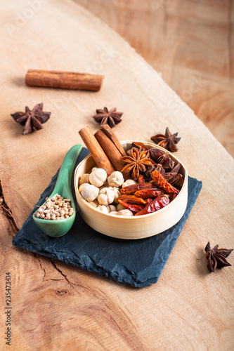 Exotic herbal Food concept Mix of the organic Spices cinnamon stick, cardamom pods, chili, star anise and coriander seedsin wooden background with copy space