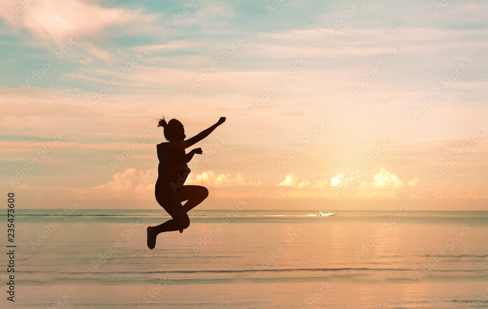 Young asian woman enjoy jumping on the beach at sunset time